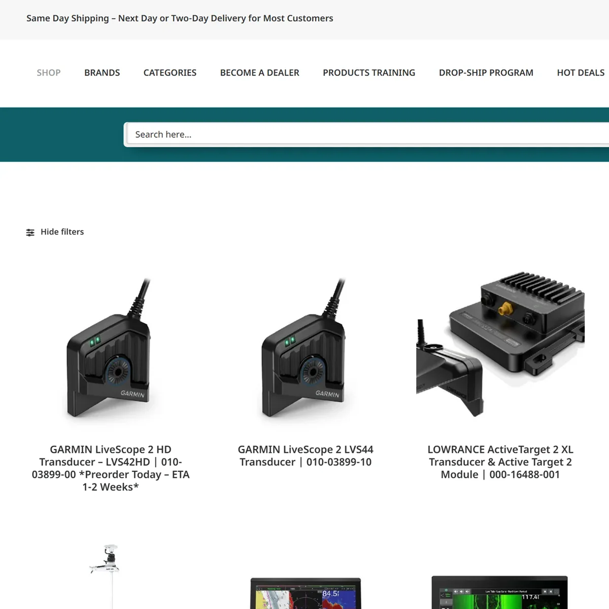 Online store category page for marine electronics, with a shipping banner and navigation menu across the top, a teal search bar, and a grid of product cards showing sonar transducers and chartplotter displays with their model names and part numbers.