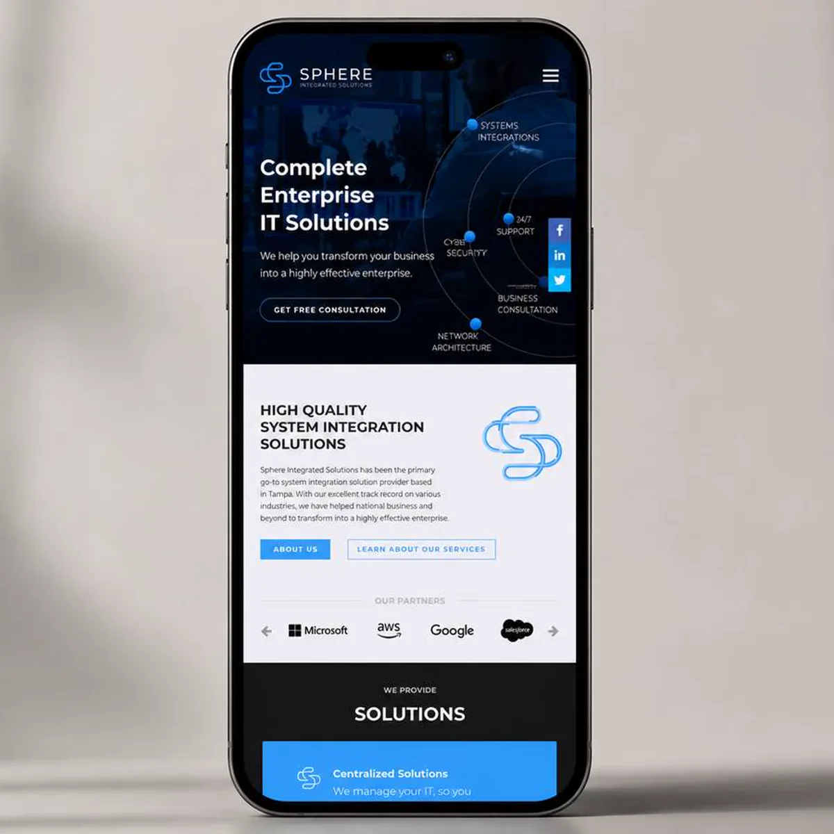 A smartphone standing upright against a soft neutral studio wall, its screen showing a corporate IT services homepage: a dark blue hero with a bold three-line headline, a short intro line, an outlined call-to-action button, and a circular diagram of service labels over a globe, followed by a white section with a system integration heading, a paragraph of body copy, two buttons, and a row of partner logos, then a black section headed Solutions with a bright blue service card.