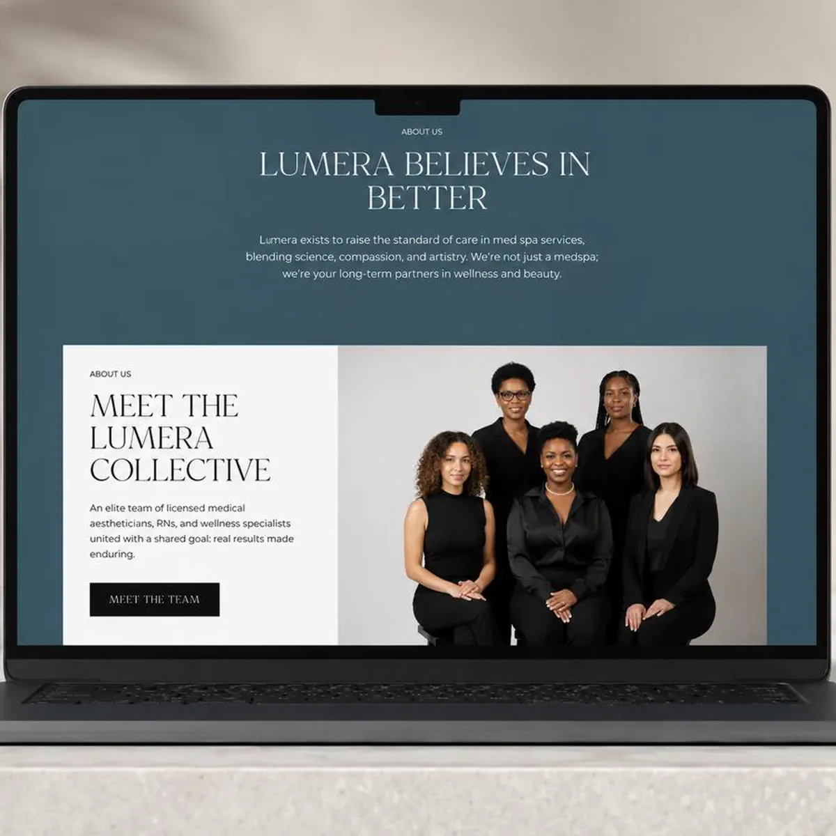 A med spa website open full screen on a laptop resting on a pale stone counter, showing an About section with a headline, a short paragraph and a portrait of the five-person team.