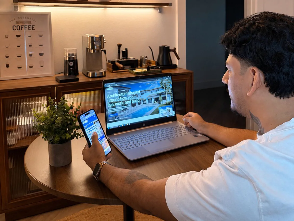 A website checked on a phone next to a laptop