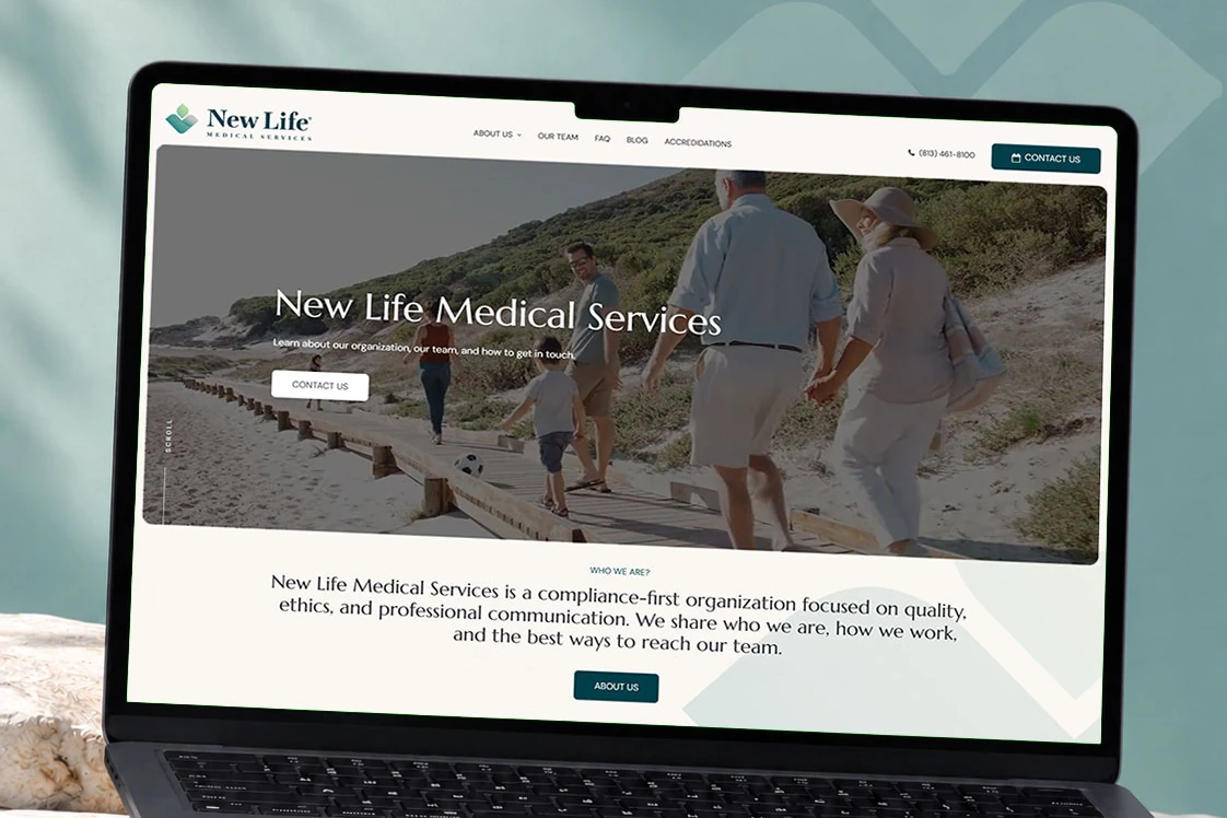 A laptop on a stone ledge showing the New Life Medical Services homepage