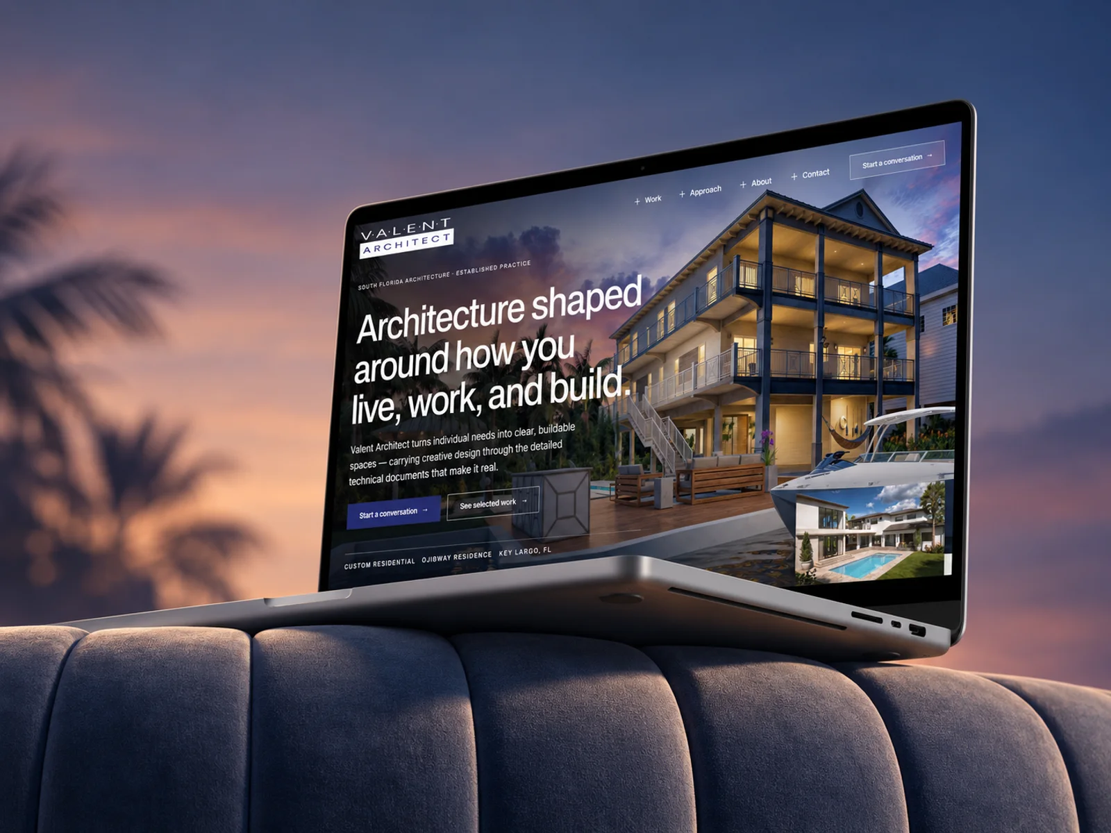 A laptop resting on a couch at dusk showing the Valent Architect homepage, with the Ojibway Residence lit behind the headline Architecture shaped around how you live, work, and build
